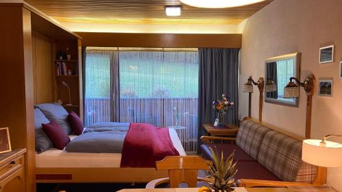 a bedroom with a bed and a large window at Studio SISI in Tauplitz