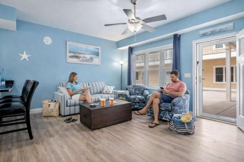 two people sitting on chairs in a living room at Harbor Hideaway 1 Block to Beach AC in Hampton