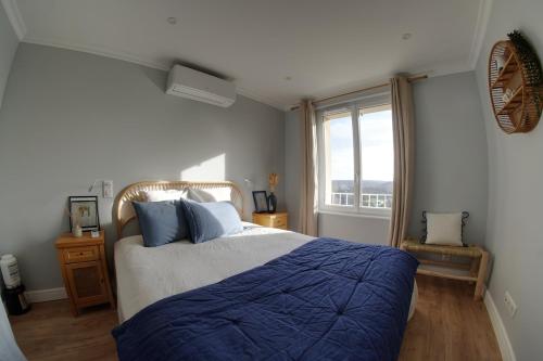 a bedroom with a bed with blue sheets and a window at Villa perchée à Cahors in Cahors