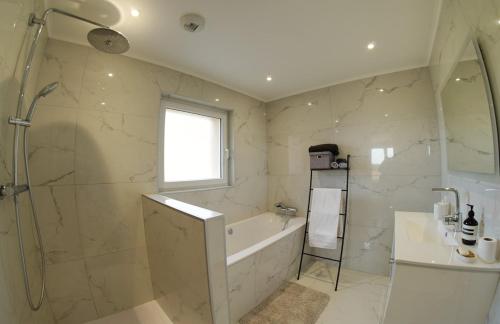 a bathroom with a shower and a tub and a sink at Villa perchée à Cahors in Cahors