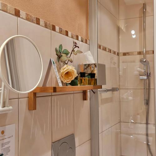 a bathroom with a mirror and a shower at Winzerhof Gietzen in Hatzenport