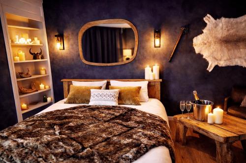 a bedroom with a bed and a mirror and candles at L'Evasion Scandinave, SPA XXL, Écran cinéma, Lit king size, day use, 10 min centre in Amiens