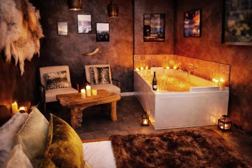 a bathroom with a tub and a table with candles at L'Evasion Scandinave, SPA XXL, Écran cinéma, Lit king size, day use, 10 min centre in Amiens
