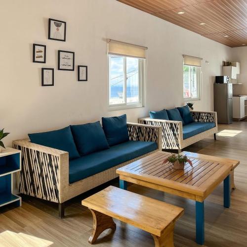 a living room with a blue couch and a table at Destino Beach Resort and Hotel in Batangas City