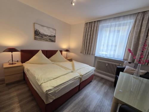 ein Hotelzimmer mit einem Bett und einem Fenster in der Unterkunft Hotel Central in Erlangen