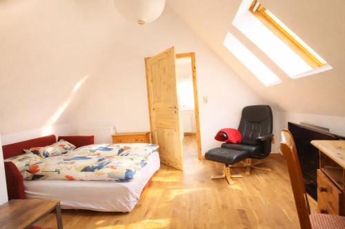 a bedroom with a bed and a chair in a attic at Stiegenstübchen am Weinberg in Dresden