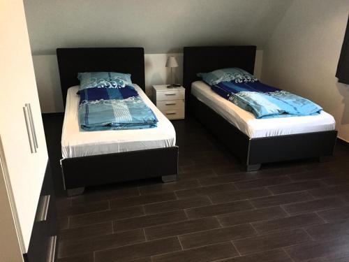 a bedroom with two beds and a tile floor at Hotel Restaurant Kroatia in Dortmund