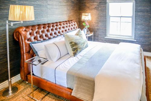a bedroom with a large bed with a leather headboard at Collection Luxury Apartments 31 Winelands Lodge in Stellenbosch