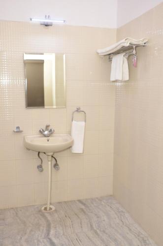 a bathroom with a sink and a mirror and towels at Amer Classic - A Heritage Stay Near Amer Fort in Jaipur