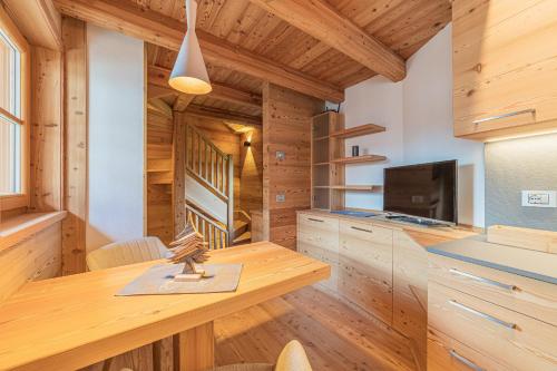 a kitchen with wooden cabinets and a wooden table at The Love Chalet in Falcade