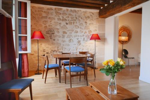 une salle à manger avec une table et des chaises et un mur en pierre dans l'établissement Apartments Cosy, à Paris