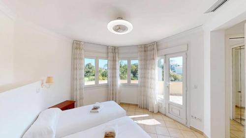 a white bedroom with two beds and a window at Greenview Villa by ON Travel in Oliva