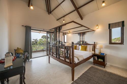 a bedroom with a canopy bed and a balcony at SaffronStays Casa Amore in Mahabaleshwar