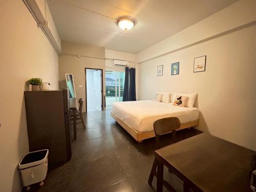 a bedroom with a white bed and a table at Comfy hotels Soi Kingkeaw31ก Alley ซอยกิ่งแก้ว31ก in Suvarnabhumi Airport