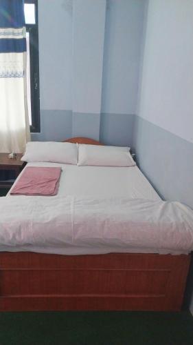 a bed with white sheets and a pink blanket on it at B N Hotel & Restaurant in Rāmechhāp