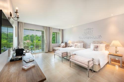a bedroom with two beds and a living room at U Khao Yai in Mu Si