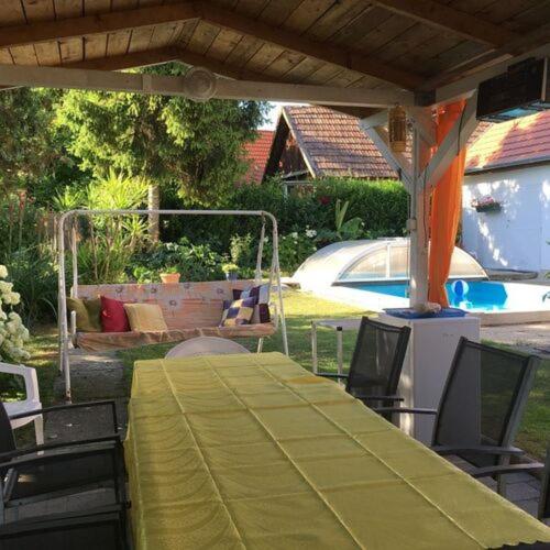 a table with a green table cloth on a patio at FLY Vendégház in Szólád