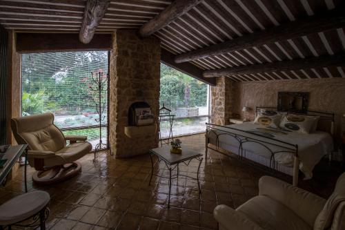 a bedroom with a bed and a chair in a room at La Ferme in Saint-Marc-Jaumegarde