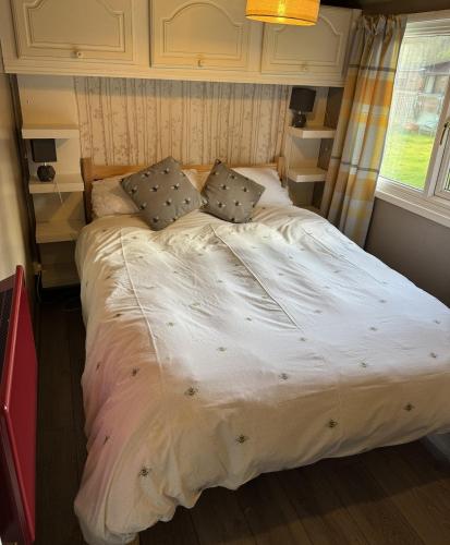 a large bed in a small room with a window at Lodge 51 - Caer Beris Park - No Tradesmen in Maesmynis