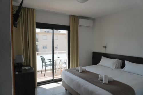 a bedroom with a bed and a balcony with a chair at Hotel Ram Rooms Tahiti in Salou