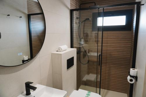 a bathroom with a shower and a sink and a mirror at Hotel Ram Rooms Tahiti in Salou