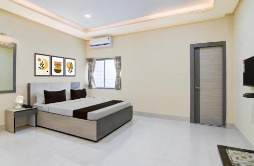 a bedroom with a bed and a television in it at Townhouse Oak Howrah Junction Kolkata in Kolkata