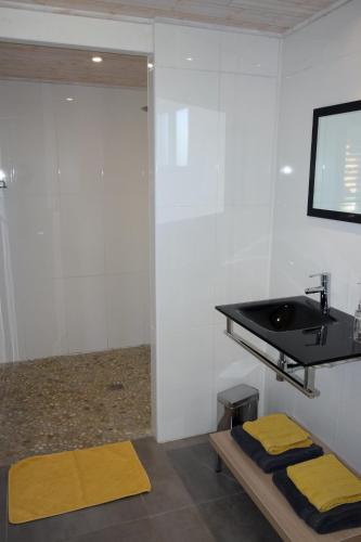 a bathroom with a sink and two yellow mats at Timazen Lodges Agen Sud in Aubiac