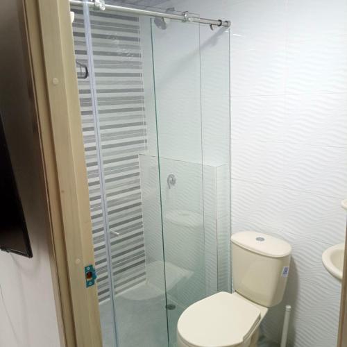 a bathroom with a toilet and a glass shower at casa trieste in Jamundí