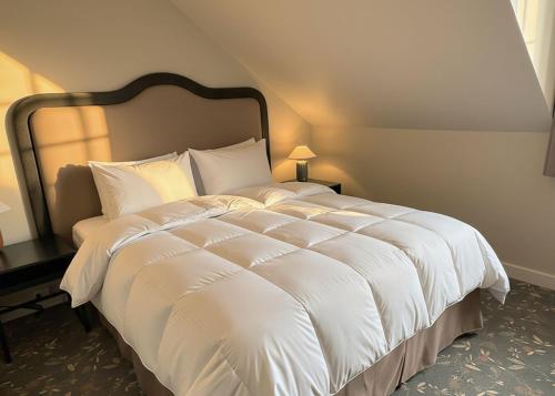 a large bed with white sheets and pillows at Havna Hotel & Sjøbad in Tjøme