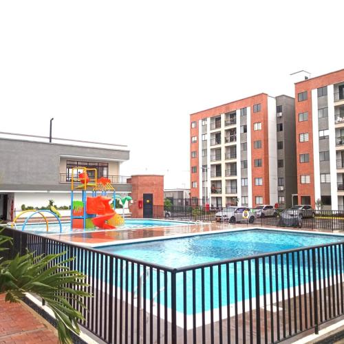 a swimming pool with a playground and some buildings at casa trieste in Jamundí