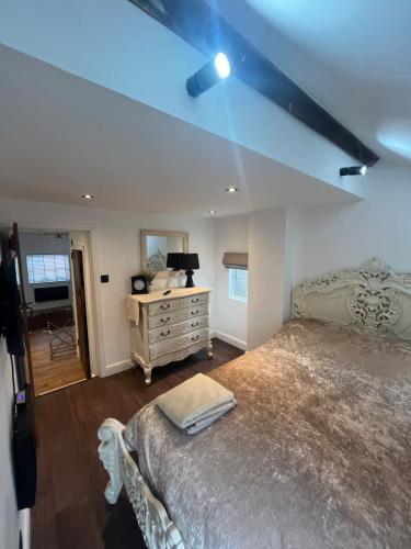 a bedroom with a large bed and a desk at Rooftop One-Bedroom Apartment Near East Midlands Airport in Castle Donington