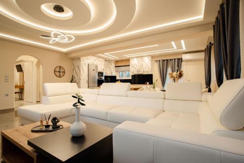 a living room with a white couch and a table at Luxury Villa Kokos-Private Pool in a Serene Natural Private Estate in Vitalades