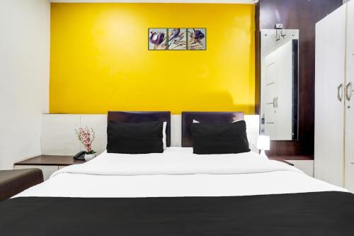 a bedroom with a large bed with a yellow wall at Collection O MP Nagar in Bhopal