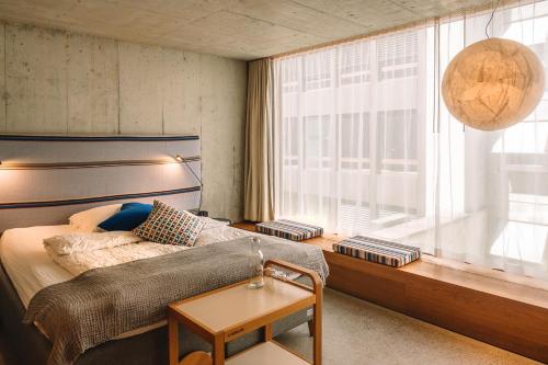 a bedroom with a bed and a large window at Nomad Design & Lifestyle Hotel - Member of Design Hotels in Basel