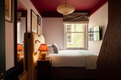 a bedroom with a white bed and a window at The Bull Hotel in Bridport