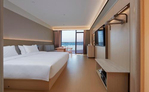 a hotel room with a bed and a view of the ocean at JI Hotel Vientiane Mekong Riverside in Vientiane