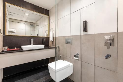a bathroom with a toilet and a sink at Mango Hill Hotel Velankanni in Velankanni