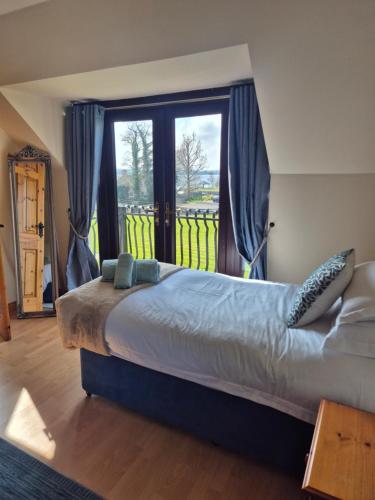 a bedroom with a bed and a large window at Harbour View Lodge in Dromod