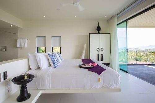 a white bedroom with a large bed with a table on it at Villa Danisa 4BR Panoramic Ocean View with Infinity Pool & Private Gym in Choeng Mon Beach