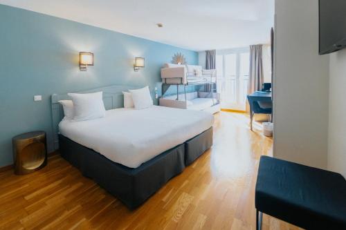 a hotel room with a large bed and a desk at Hotel Albert 1er in Toulouse