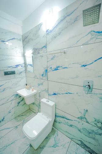a bathroom with a white toilet and a sink at Veedu and Co Greens in Cochin