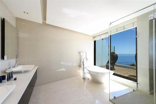 a bathroom with two sinks and a toilet and a window at Azamare Guest House in Cape Town