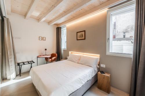 a bedroom with a white bed and a window at Margherita Home in Reggio Emilia