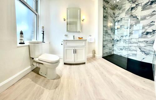 a white bathroom with a toilet and a shower at Falls of Lora Hotel in Oban