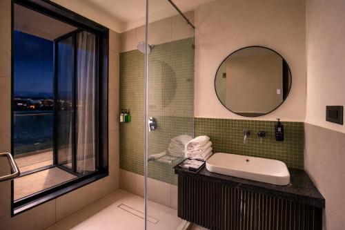 a bathroom with a sink and a glass shower at Avisa Hotel & Resort Abu Road - Luxury Pool & Mountain View in Ābu Road