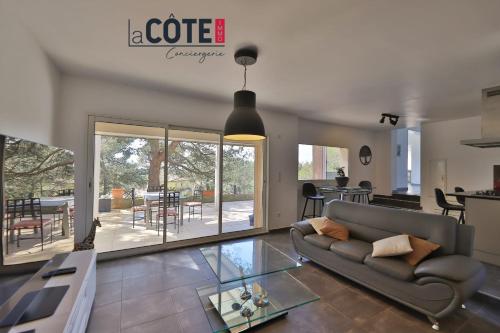 a living room with a couch and a glass table at Villa Laterra in Ensuès-la-Redonne