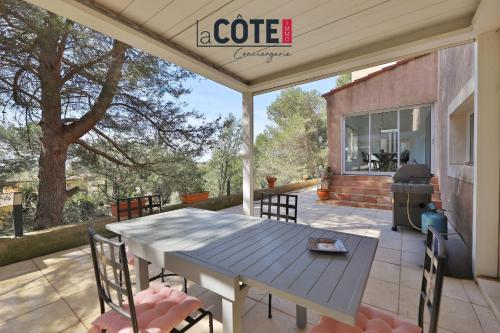a patio with a blue table and chairs on it at Villa Laterra in Ensuès-la-Redonne