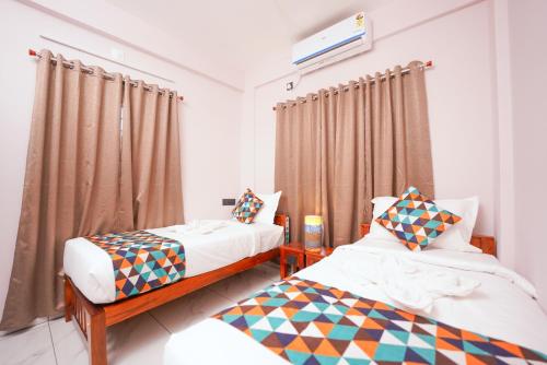 a bedroom with two beds and a window at Veedu and Co Greens in Cochin
