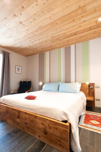 a bedroom with a large bed with a wooden ceiling at Casa Monet 41 in Saint Vincent