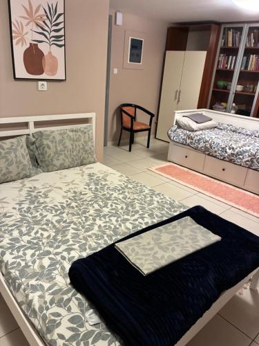 a bedroom with two beds and a chair in it at Studio Almyros in Almiros